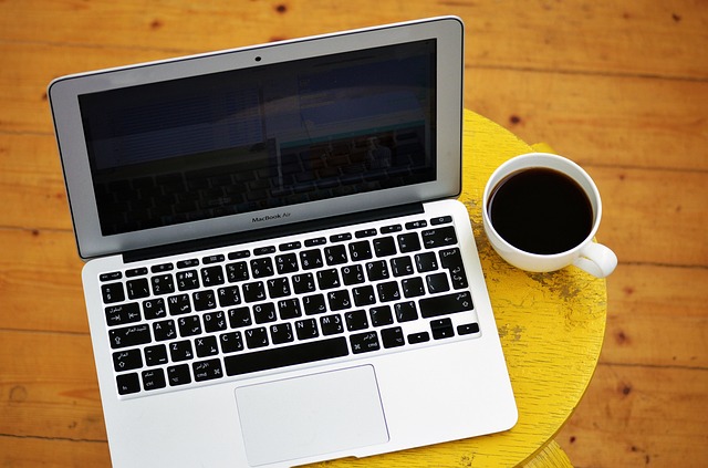 Laptop ouvert avec écran vide sur un bureau, accompagné d'une tasse de café, illustrant le début du processus de création d'un site web one page pour indépendants et petites entreprises.